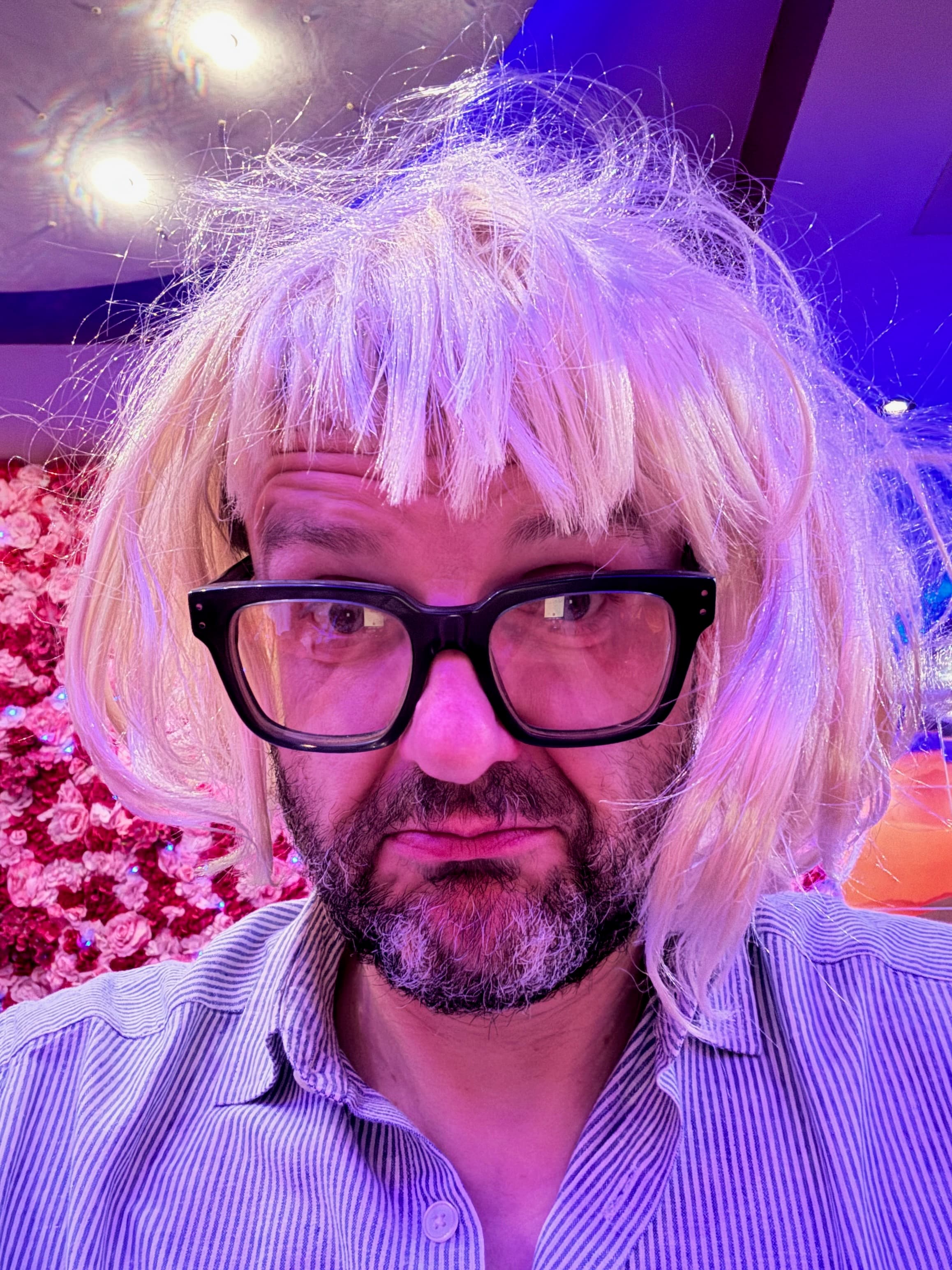 Portrait of a guest in a blonde wig under red lighting