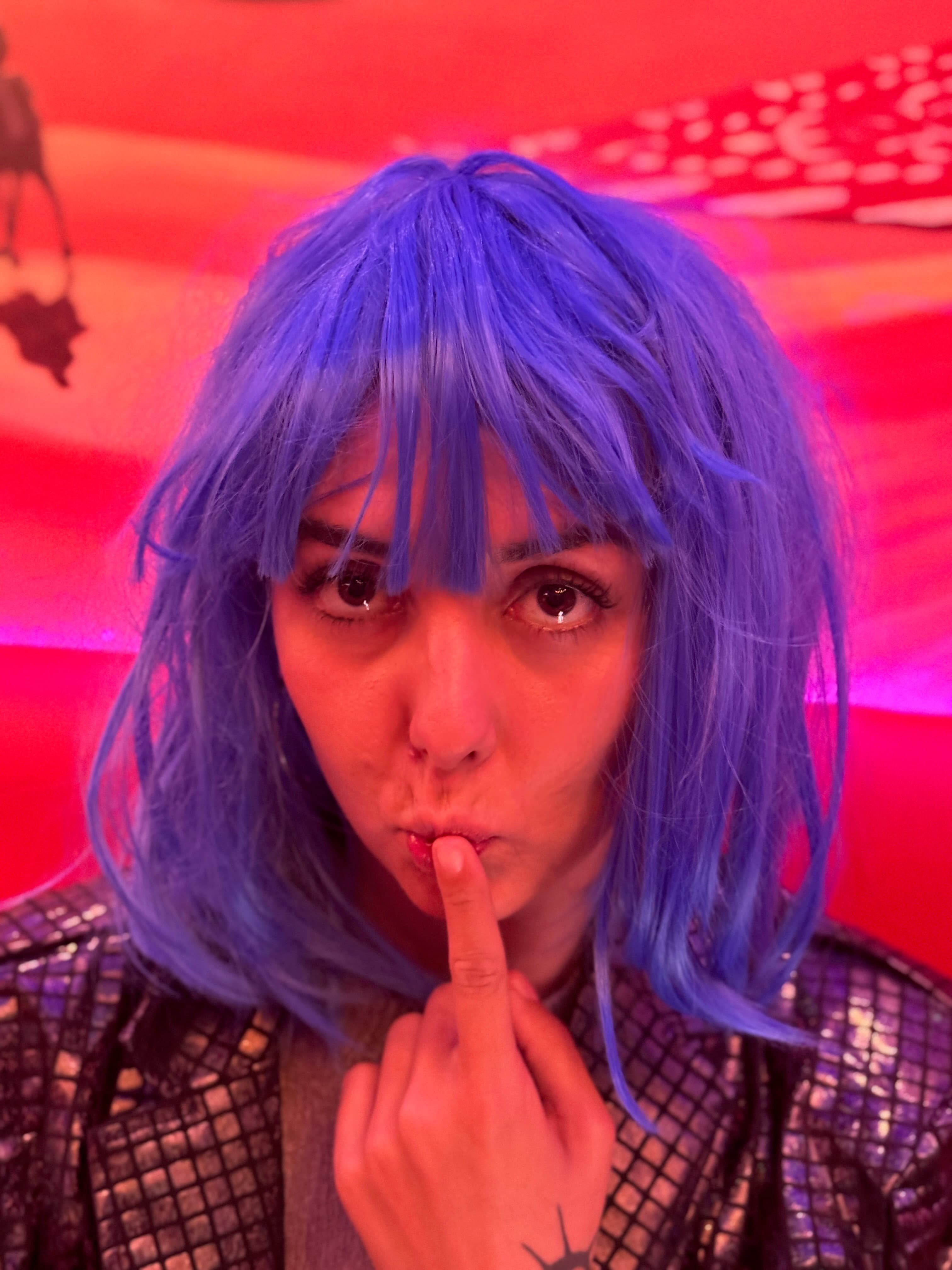 Party portrait with a bright blonde wig and playful expression