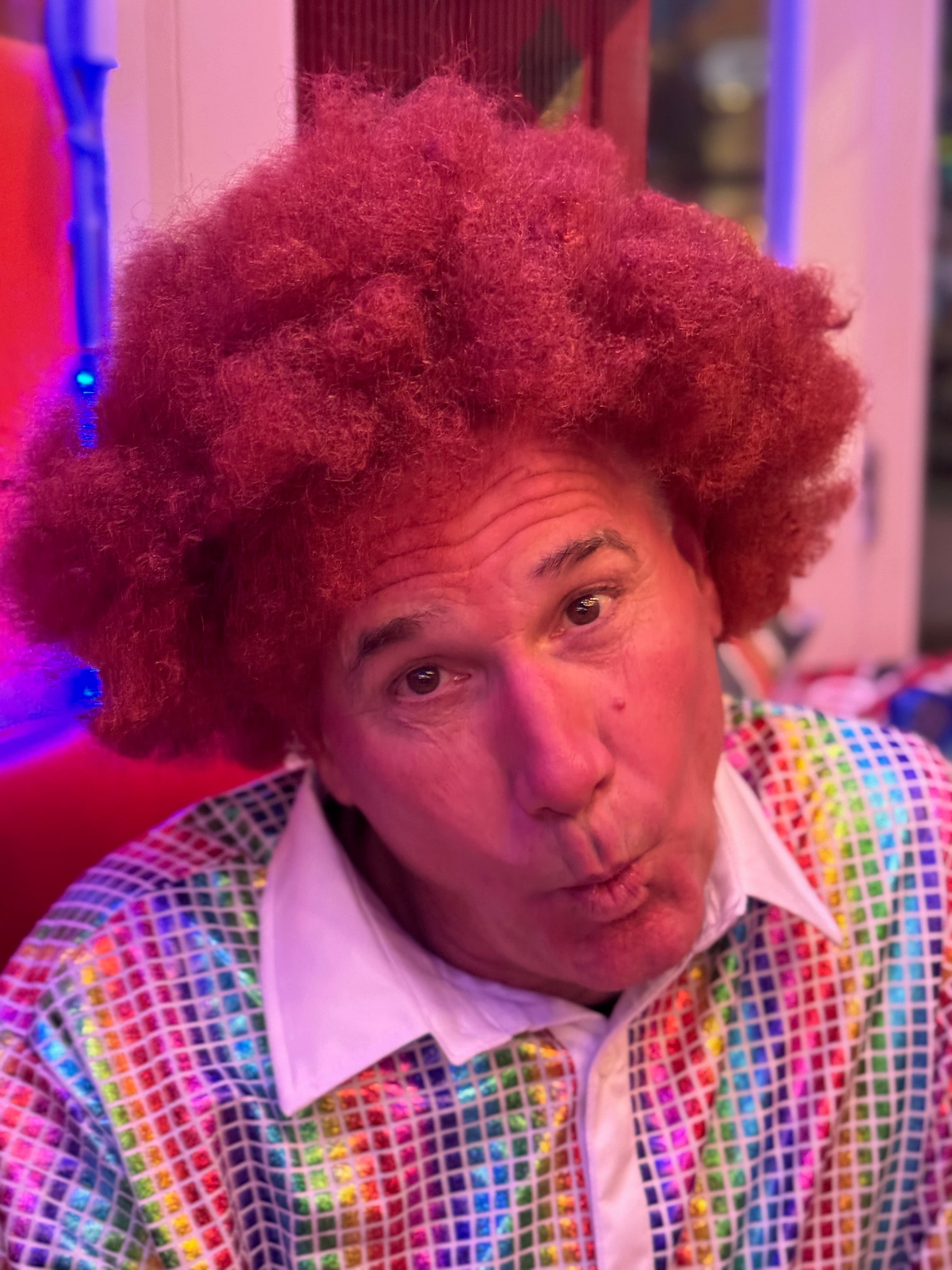 Portrait of a guest in a long wig with warm party lighting