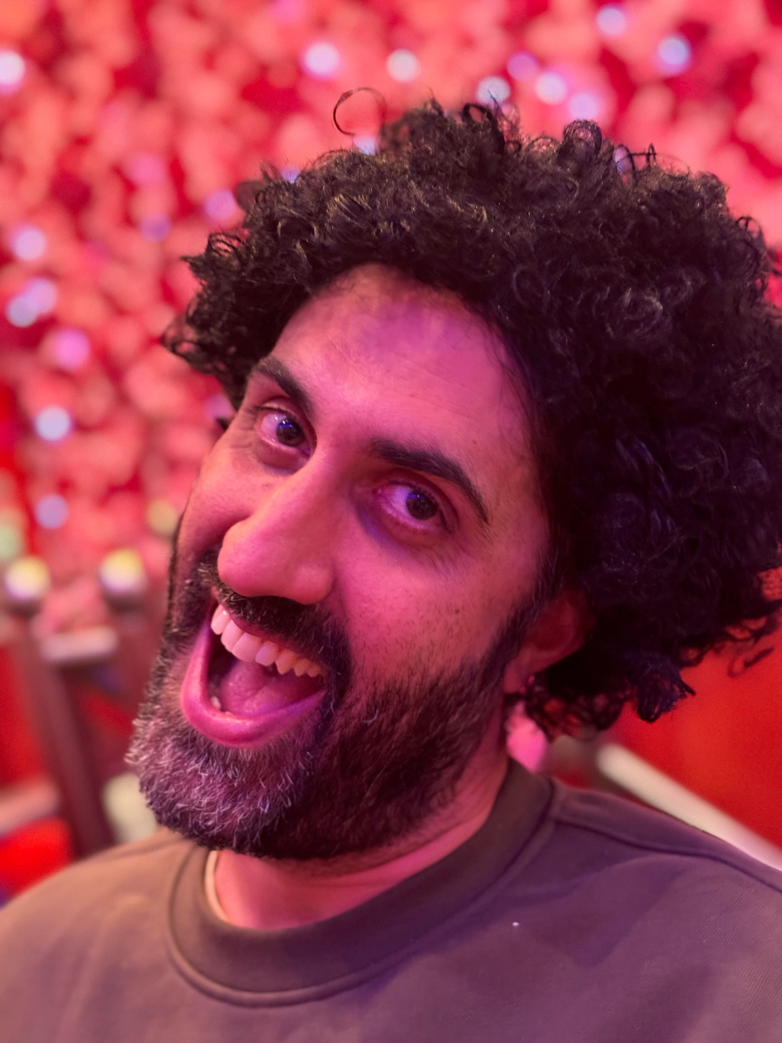 Expressive close-up portrait in a wig at a red-lit event