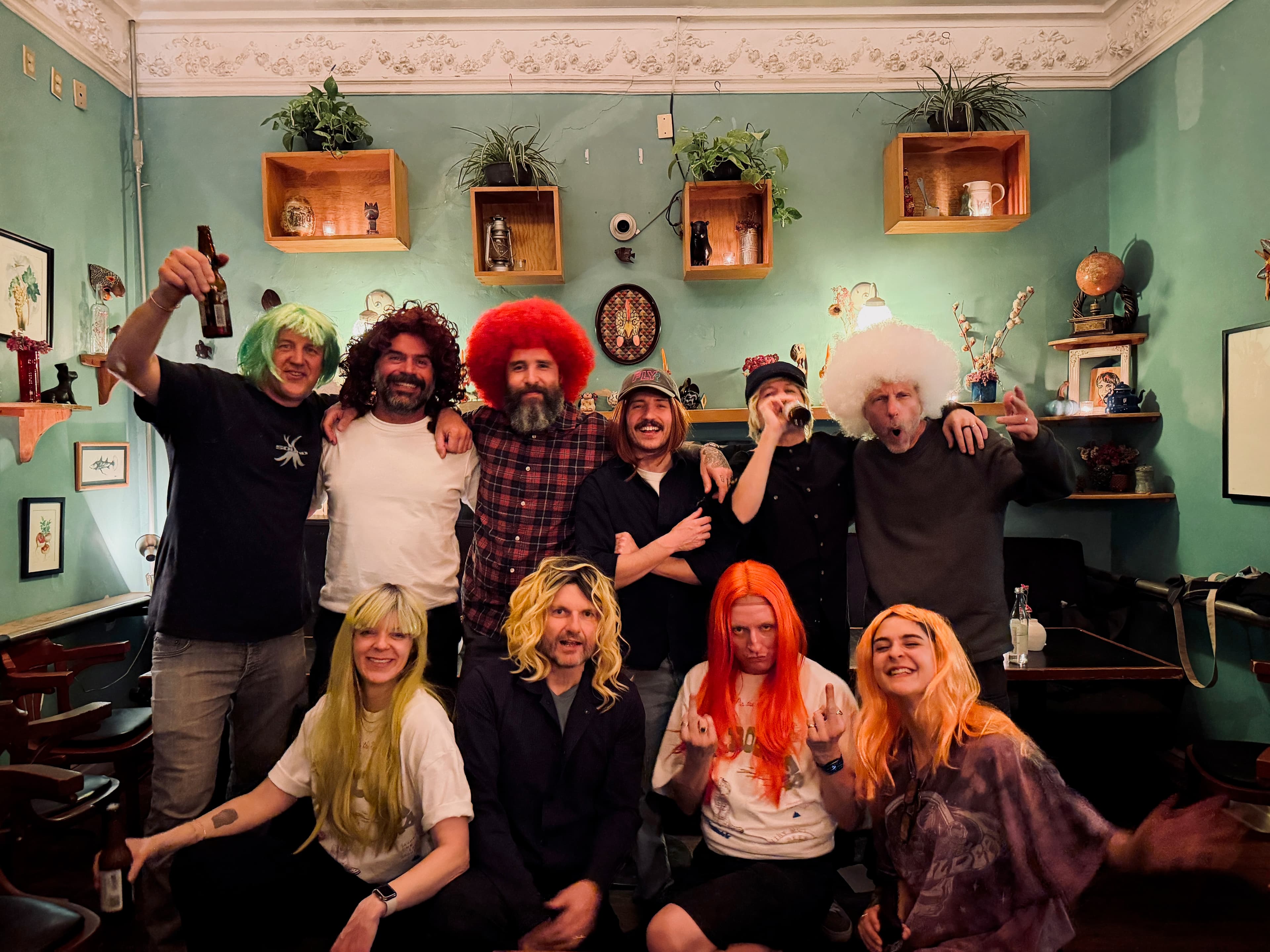 Large group in colorful wigs posing together indoors