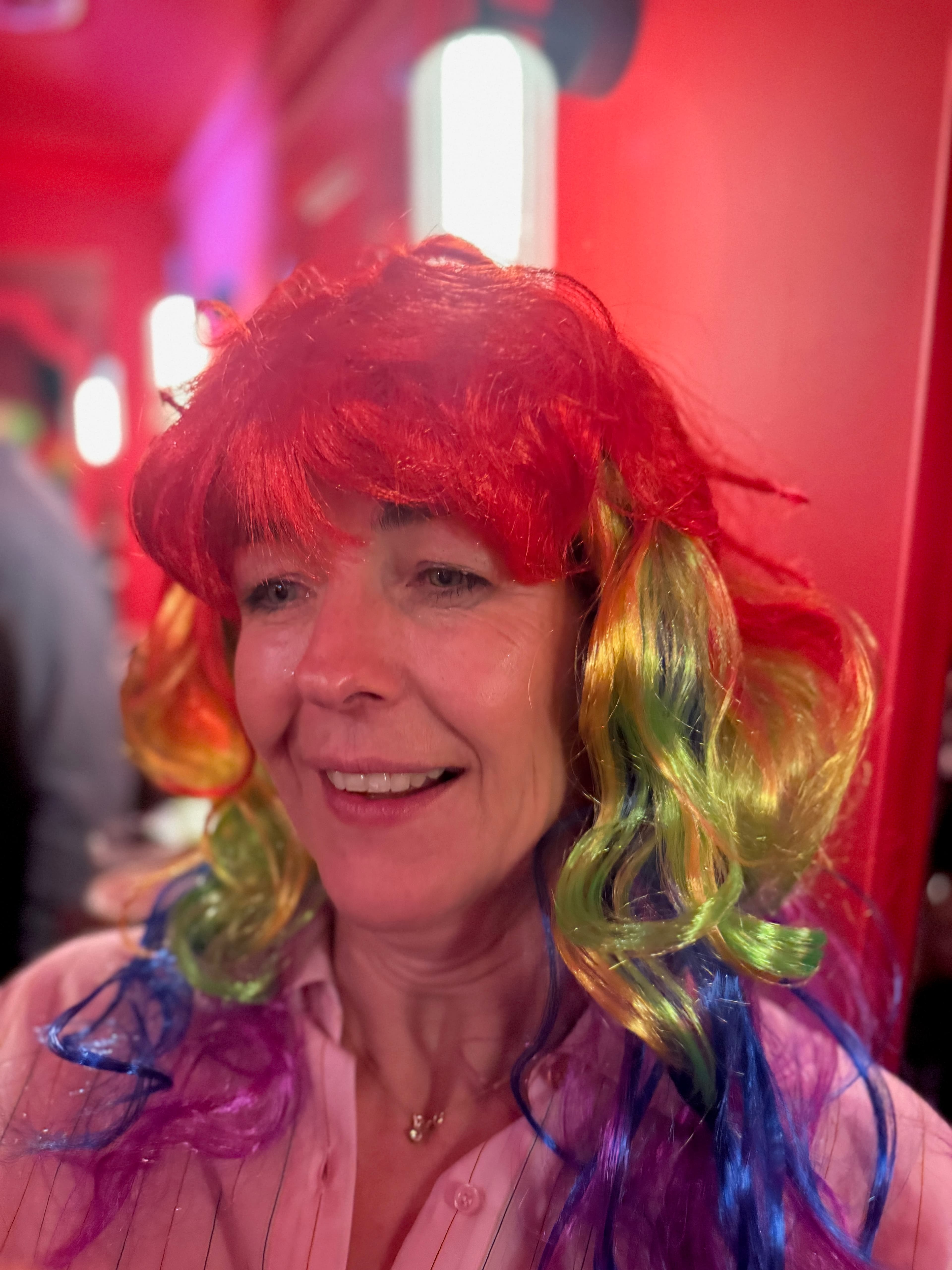 Guest in a styled wig posing in a vibrant indoor party scene