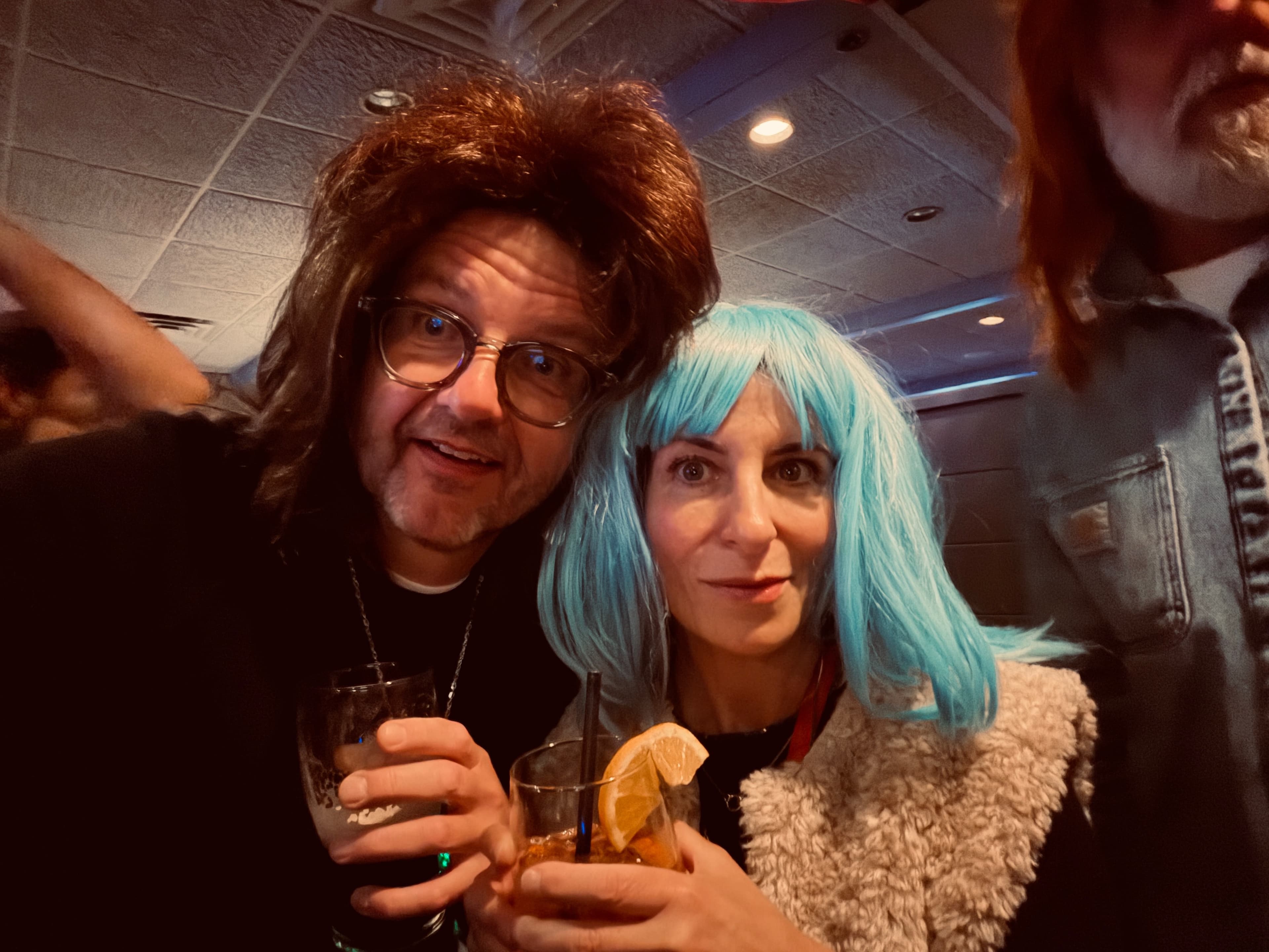 Couple in wigs holding cocktails